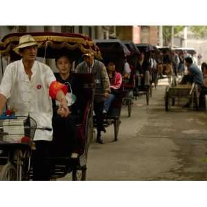 Rickshaws Driving through the Narrow Streets in Hutong, Beijing, China 
