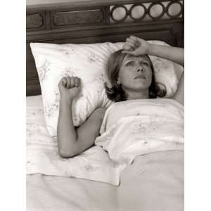 Close Up of Woman Lying in Bed With Pained Expression Photographic 